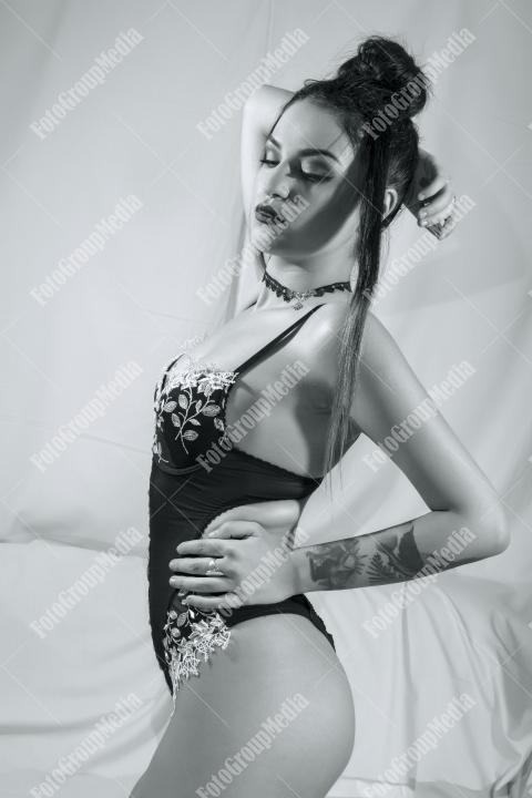 Woman posing in black lingerie on white background