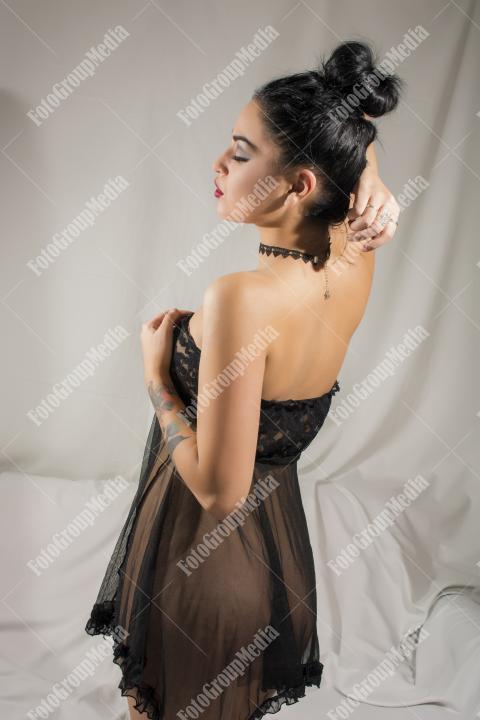 Woman posing in black lingerie on white background