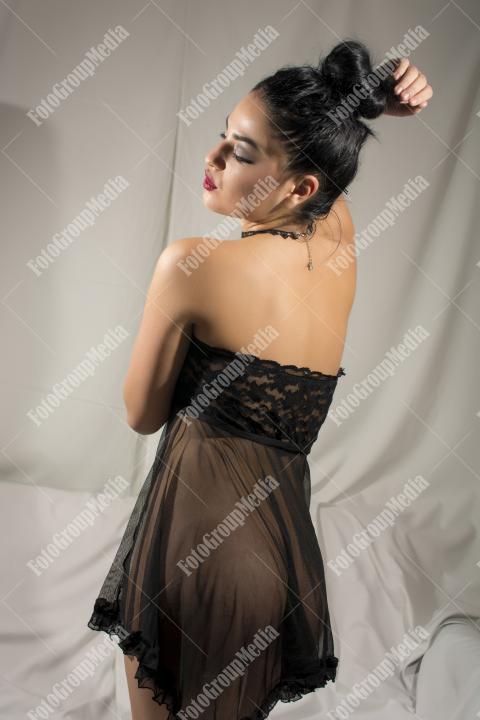 Woman posing in black lingerie on white background