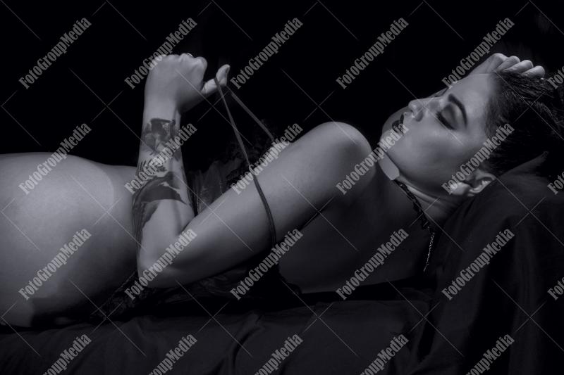 Woman posing in lingerie on black background, B&W